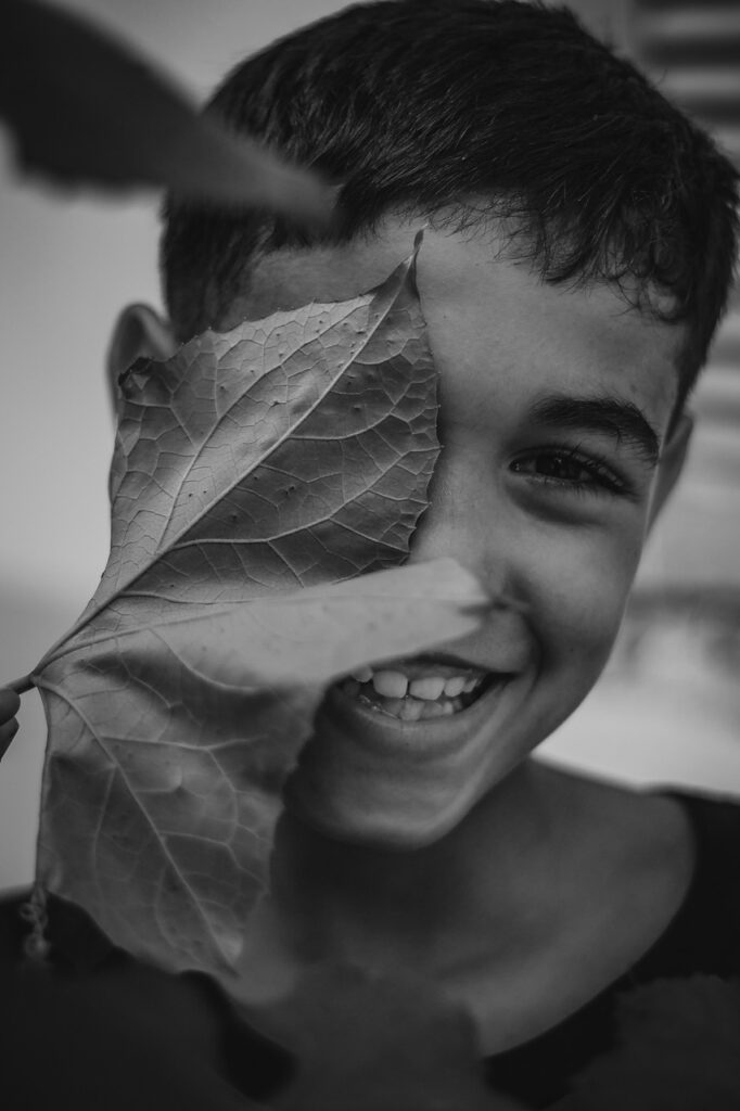 smile, boy, kid, leaf, happy, nature, child, portrait, smiling, laughing, cute, young, face, creative, black and white, emotion, outdoor, leaves, one eye, inspiration, photo, photos, great smile, love, valentines, happy valentines